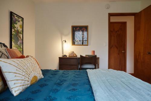 a bedroom with a bed with a dresser and a desk at Catskills Retro Retreat- Upstate Home W Hot Tub in Saugerties