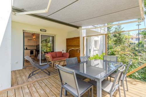un patio avec une table et des chaises sur une terrasse dans l'établissement Atlantic Selection - Le Duna - Ambiance zen avec terrasse & parking, à Capbreton