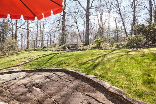 a red umbrella sitting on top of a grass field at Catskills Retro Retreat- Upstate Home W Hot Tub in Saugerties