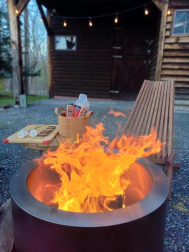 a fire in a barrel next to a bench at Catskills Retro Retreat- Upstate Home W Hot Tub in Saugerties