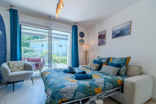 a bedroom with a bed and a sliding glass door at Atlantic Selection - Le Duna - Ambiance zen avec terrasse & parking in Capbreton