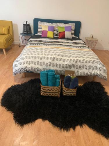 a bedroom with a bed with two baskets and a rug at Belle chambre d'hôtes cosy proche Disneyland in Boissy-le-Châtel