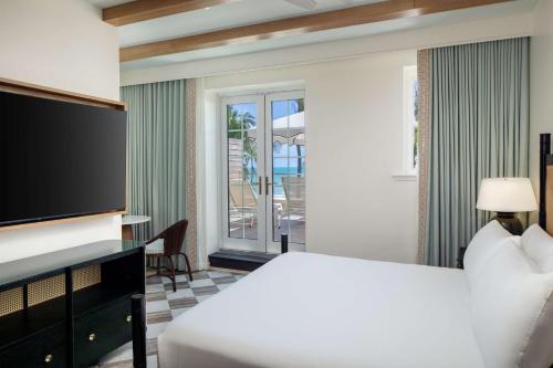 a hotel room with a bed and a flat screen tv at Casa Marina Key West, Curio Collection by Hilton in Key West