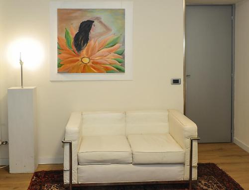 a white couch in a living room with a painting at Villa Paolina in Sulzano