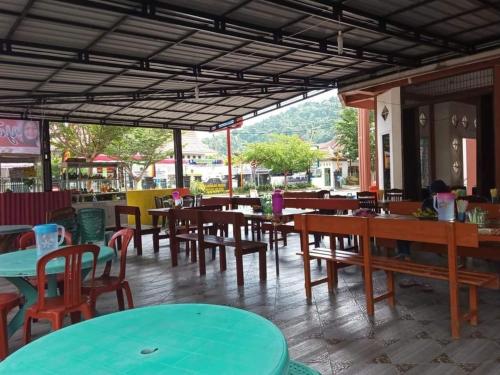 PainanにあるBurma Residence Syariah Painan Pesisir Selatan West Sumateraのテーブル、椅子、テーブル、椅子が備わる空きレストランです。