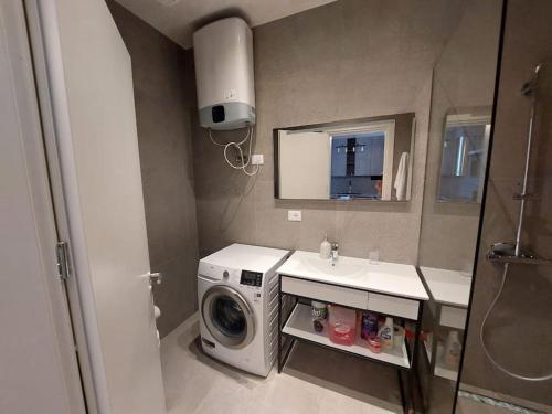 a bathroom with a washing machine and a sink at Palase Four C apartment 243-E GC in Palasë