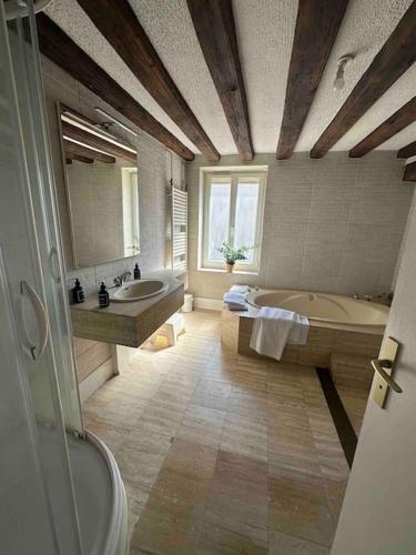La grande salle de bains est pourvue de 2 lavabos, d'une baignoire et d'une douche. dans l'établissement Grande maison de ville, 2 chambres, à Orléans