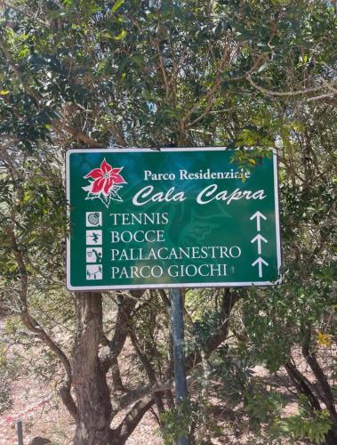 a green sign in front of a tree at Oasi CalaCapra - Palau Costa Smeralda in Proiettore