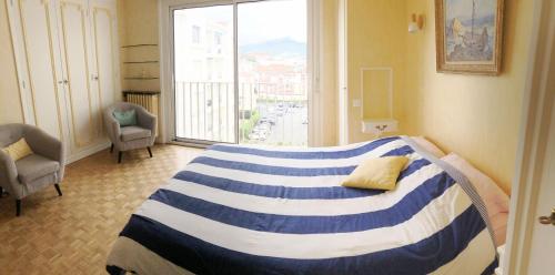 1 dormitorio con cama y ventana grande en Spacieux appartement vue Océan et Rhune, en San Juan de Luz