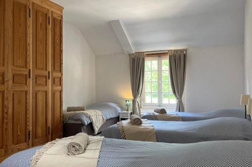 - une chambre avec 3 lits et une grande fenêtre dans l'établissement Maison de campagne entre Caen et la mer, à Loucelles