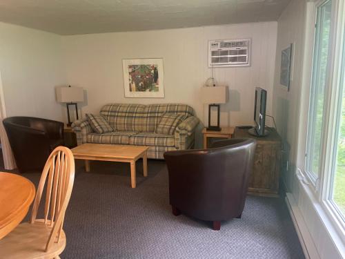 a living room with a couch and a table at Colonial Bay Motel and Cottages in Huntsville