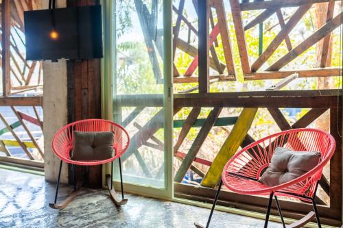 dos sillas rojas sentadas frente a una ventana en Papelillo Lofts, en Sayulita