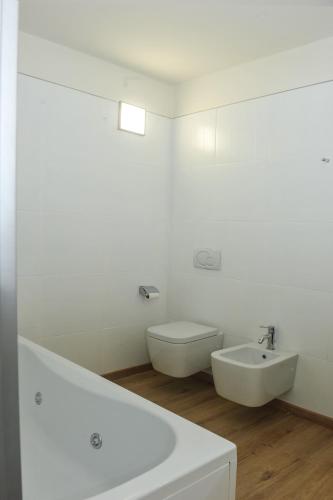 a white bathroom with a sink and a toilet at Villa Paolina in Sulzano