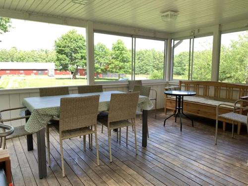 a dining room with a table and chairs and windows at Skirsnäs gård in Växjö