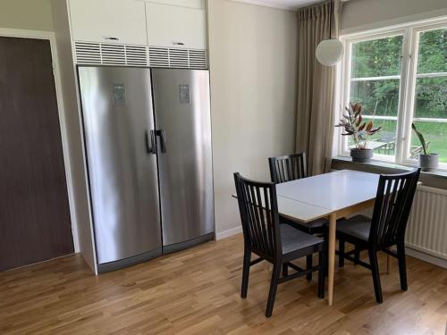 a kitchen with a table and chairs and a refrigerator at Skirsnäs gård in Växjö