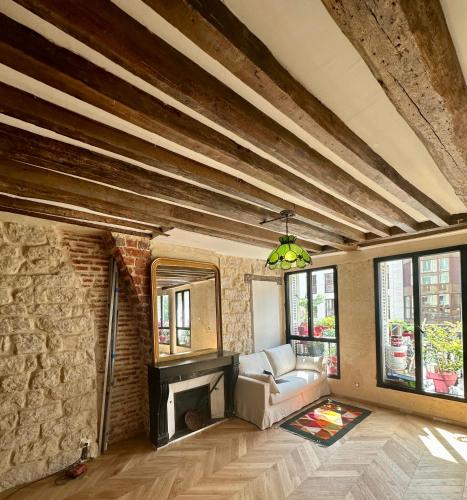 un salon avec un canapé et une cheminée dans l'établissement Appartement cosy, à Paris