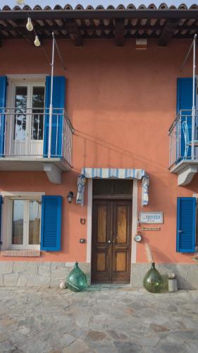 a building with blue windows and a wooden door at B&B La Buonora in Sinio