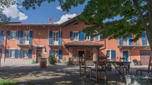 an orange building with chairs and a table in front of it at B&B La Buonora in Sinio