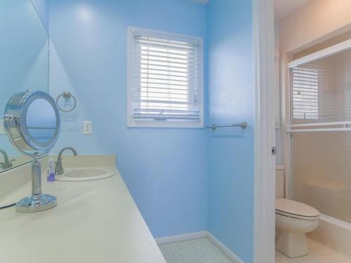 a bathroom with a sink and a mirror and a toilet at As Good As It Gets in Surf City
