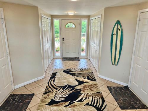 a hallway with a door with a surfboard on the wall at As Good As It Gets in Surf City