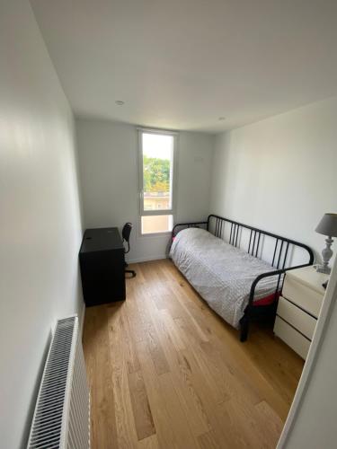 a bedroom with a bed and a window at Bel appartement au bord d Yerres in Yerres