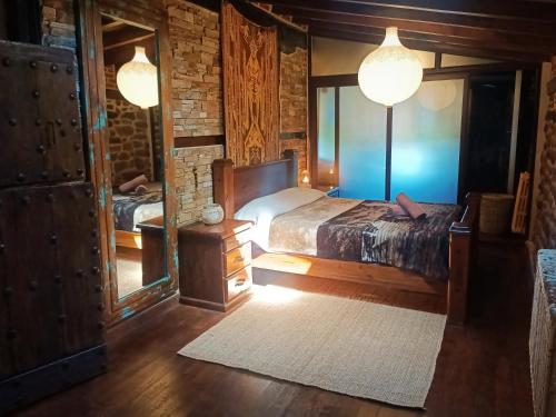 a bedroom with a bed and a mirror at La cabaña mirador de los Valles Pasiegos in Vega de Pas