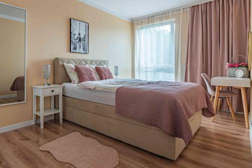 a bedroom with a large bed and a window at Nowy apartament - Bulwary nad Sołą - 52m2 in Oświęcim