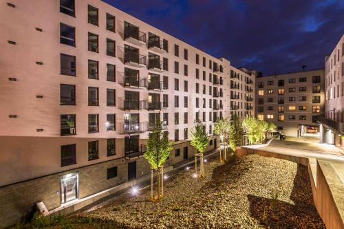 a building with a courtyard with trees in front of it at Nowy apartament - Bulwary nad Sołą - 52m2 in Oświęcim