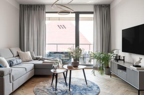 een woonkamer met een bank en een tv bij Old Town - River Point by Welcome Apartment in Gdańsk