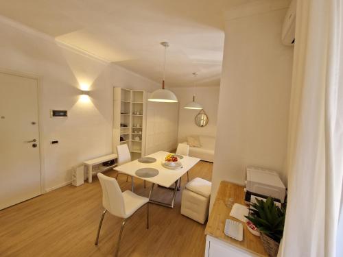 a dining room and living room with a table and chairs at La Casa Bianca di Jo in La Spezia