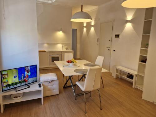 a kitchen and living room with a table and a television at La Casa Bianca di Jo in La Spezia
