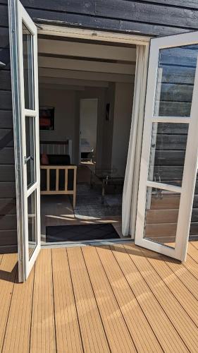 an open door to a porch with a deck at Tversted Strandpark in Bindslev