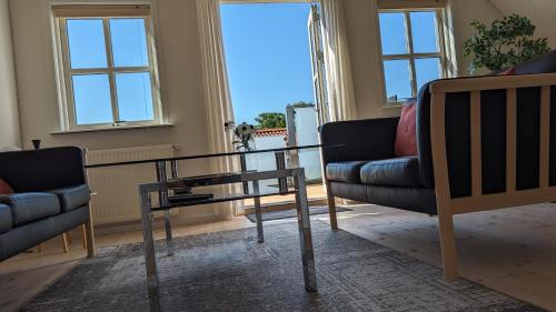 a living room with two chairs and a glass table at Tversted Strandpark in Bindslev