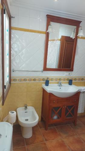 a bathroom with a sink and a toilet and a mirror at Casa cheve in Cangas de Morrazo