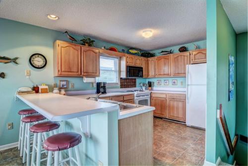 a kitchen with wooden cabinets and a white refrigerator at Back A Bit in Surf City