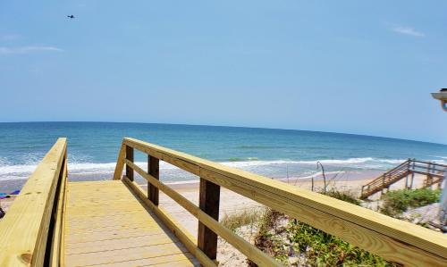 a wooden boardwalk leading to a beach with the ocean at Back A Bit in Surf City