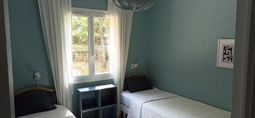 Cette chambre bleue comprend 2 lits et une fenêtre. dans l'établissement Villa au cœur de la Provence, à Lorgues