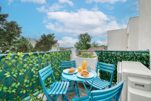 une table avec deux chaises et deux assiettes de nourriture sur un balcon dans l'établissement First flight Colomiers - à 8 mn de l'aéroport- Proche Airbus - 6 voyageurs, à Colomiers