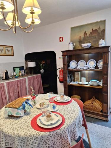 a dining room table with plates and dishes on it at Quinta dos Chorões in São Vicente Ferreira