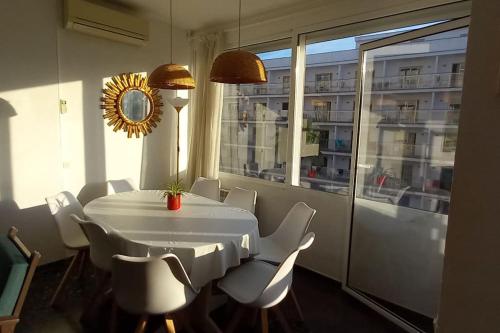 ein weißer Tisch und Stühle in einem Raum mit einem Fenster in der Unterkunft Salou, Port Aventura, piscina, a 80m del mar in Salou