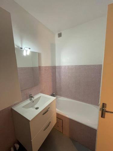 une salle de bain avec un lavabo et une baignoire dans l'établissement Studio accès plage, à Six-Fours-les-Plages