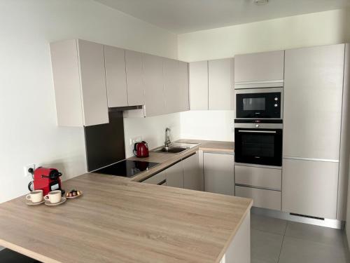 a kitchen with white cabinets and a wooden counter top at Central apartment in Luxembourg City Center -Parking in Luxembourg