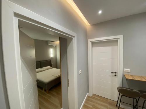 1 dormitorio con 1 cama y una puerta que conduce a una habitación en Bliss Apartment - Luxury and Cosy, en Berat