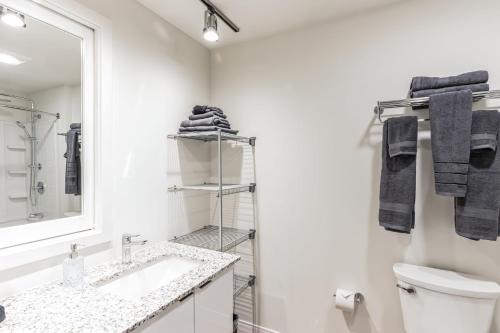 a white bathroom with a sink and a mirror at Urban Elegance Studio Oasis Prime Location in Cleveland