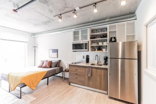 a kitchen and living room with a stainless steel refrigerator at Urban Elegance Studio Oasis Prime Location in Cleveland