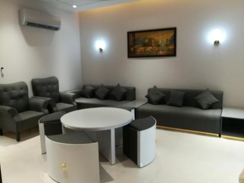 a living room with a couch and a table and chairs at Maskan in Islamabad