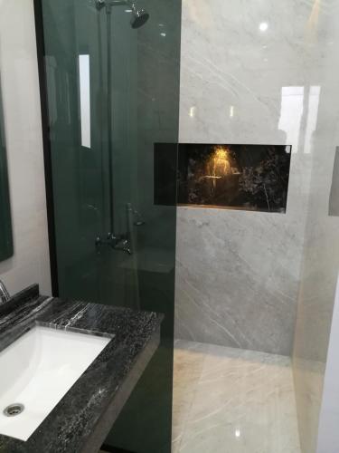 a bathroom with a shower and a sink and a shower at Maskan in Islamabad