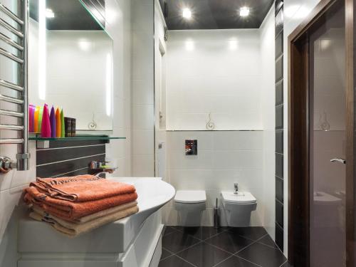 a white bathroom with a sink and a toilet at Center Apartment in Minsk