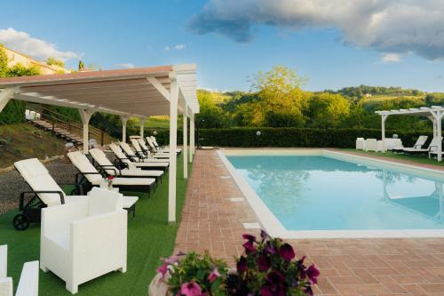 a swimming pool with lounge chairs and a pavilion at Casale Serena in Fabro