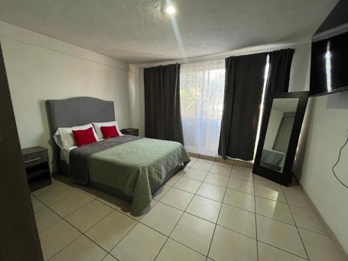 une chambre avec un lit avec des oreillers rouges et une fenêtre dans l'établissement 3 VENATOR House Boutique, à León